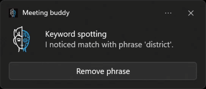 Screenshot of a 'Meeting Buddy' feature displaying a notification that a keyword 'district' has been spotted in the meeting audio, with an option to remove the phrase.